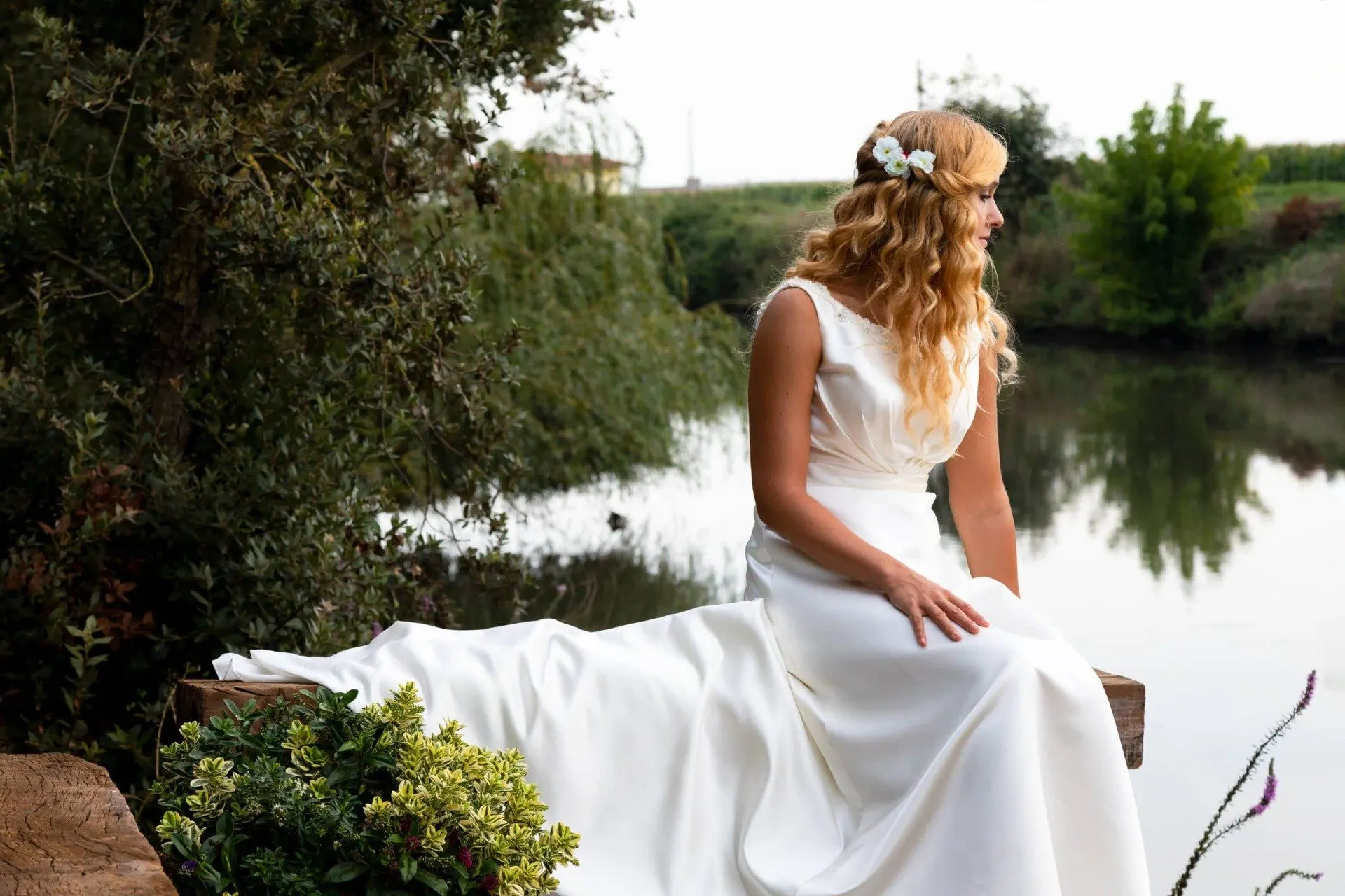 La sposa seduta sul molo, con il fiume alle spalle
